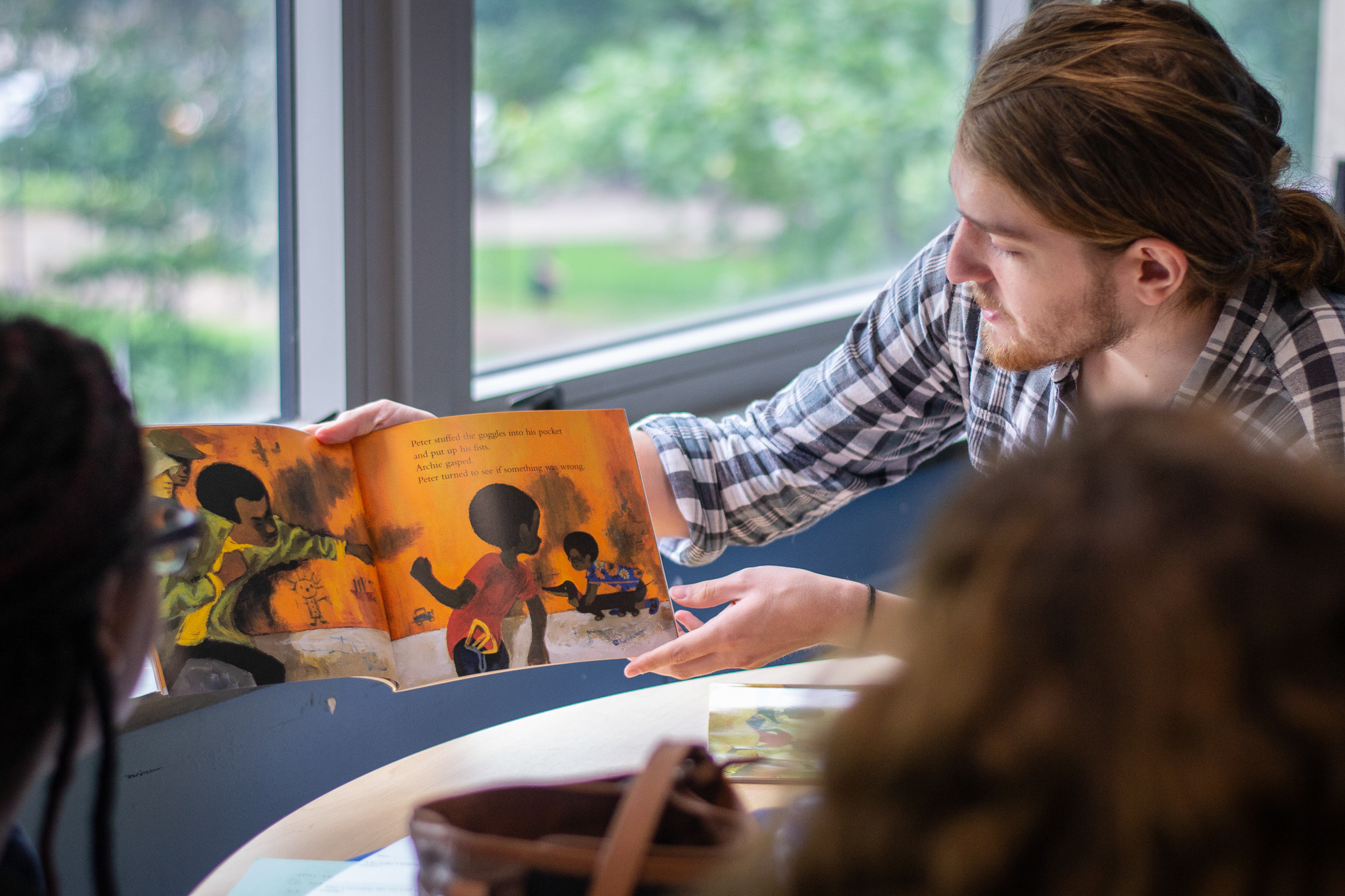 Student reading a book to children